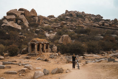 Rear view of woman with bicycle exploring ancient village