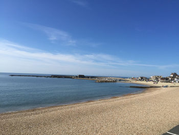 View of calm beach against blue sky