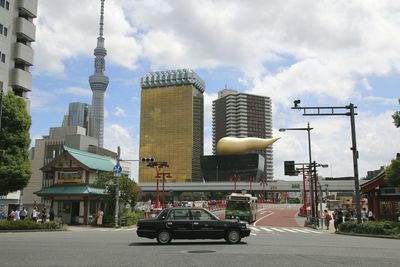 Cars on road against sky in city