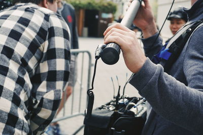 Midsection of man holding camera