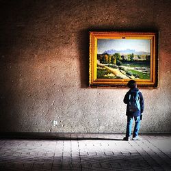 Rear view of boy standing against wall