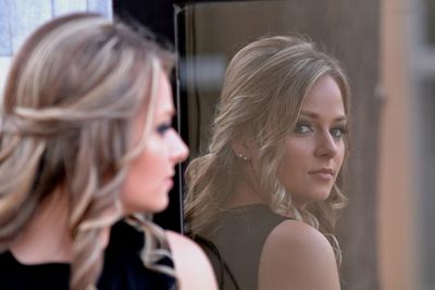 Portrait of young woman reflecting in mirror