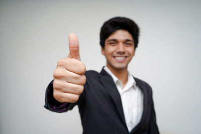 Portrait of smiling young man against white background