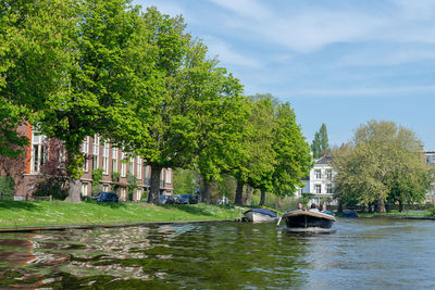 Canal by trees against sky