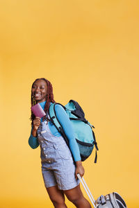 Side view of mother and daughter against yellow background