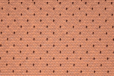 Fragment of a tiled roof of an old building in vienna. design of a red roof of made of shingles.