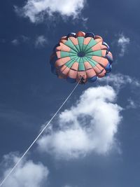 Low angle view of person parasailing against sky