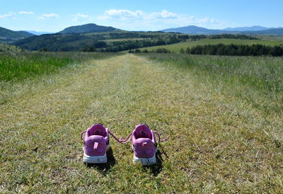 Sneakers on grass mountain road to hills and valleys