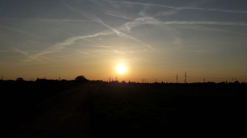 Silhouette field against sky during sunset