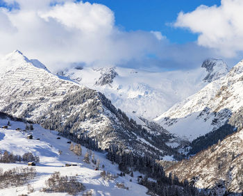 Scenic view of snow covered mountains against sky