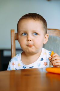 Portrait of cute boy sitting on table