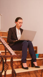 Portrait of businessman using laptop while sitting on table