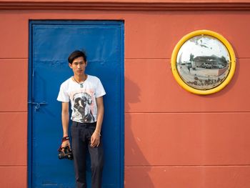 Portrait of man standing against wall