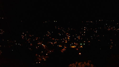 Illuminated cityscape against sky at night