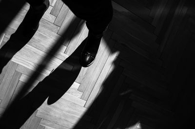 Low section of person standing on hardwood floor