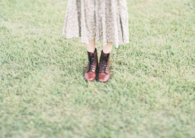 Low section of woman standing on grass