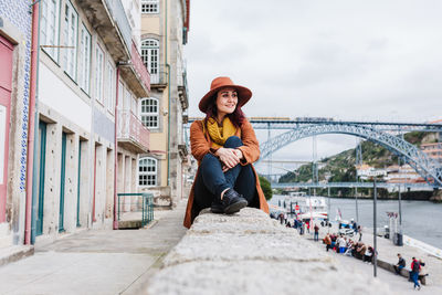 Portrait of young woman on bridge in city