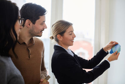 Real estate agent with couple choosing from color samples for new house