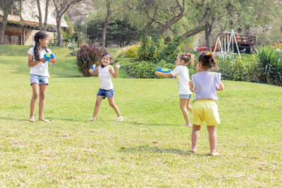 Girls playing in lawn with squirt gun