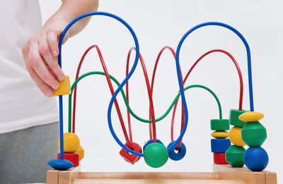 Midsection of person playing puzzle on table against white background