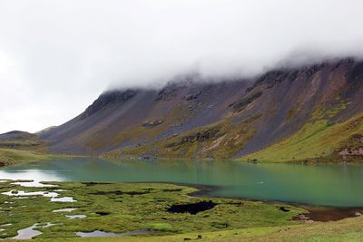 Scenic view of lake by mountains against sky