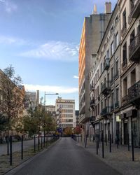 Street amidst buildings against sky in city