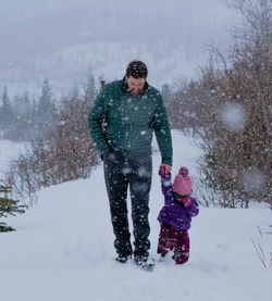 Father and son on snow during winter