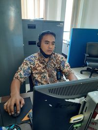 Young man using mobile phone while sitting on table