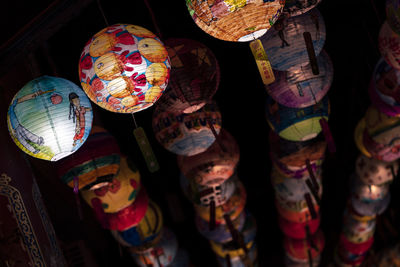 Close-up of illuminated lanterns hanging at market stall