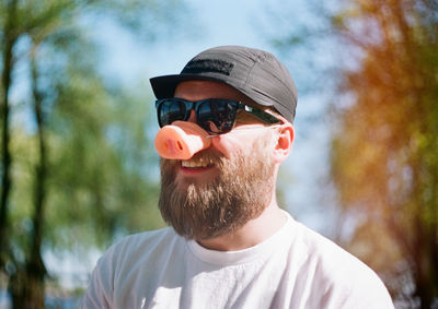 Portrait of young man wearing sunglasses and pig mask