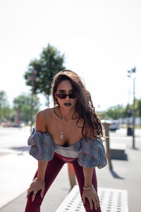 Portrait of fashionable young woman wearing sunglasses in city during sunny day