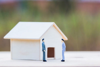 Rear view of men walking on footpath against building