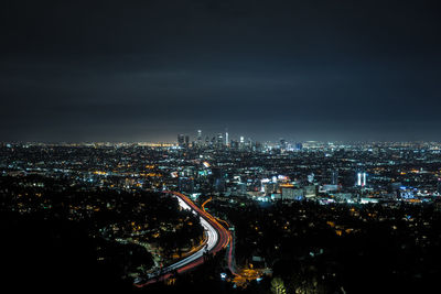 High angle view of illuminated city against sky at night