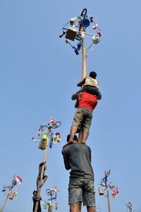 Low angle view of woman standing against clear sky