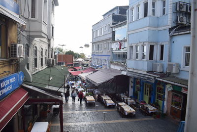 People on street amidst buildings in city