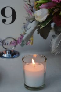 Close-up of illuminated tea light candle on table