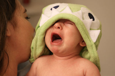 Bath time blues.  mother soothes her baby after first time in the bath tub.