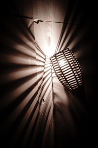 Low angle view of illuminated electric lamp on ceiling