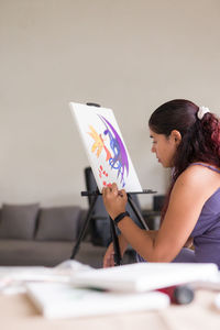 Side view of woman using laptop while sitting on table