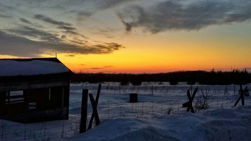 Scenic view of snow covered landscape at sunset