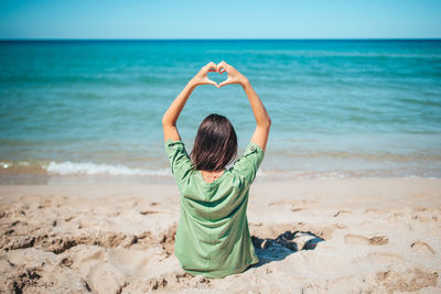 Rear view of woman standing at beach