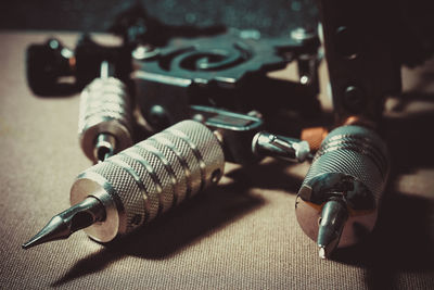 High angle view of tattoo machines on textile