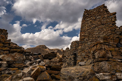 Low angle view of old ruin building against cloudy sky stepantsminda, georgia