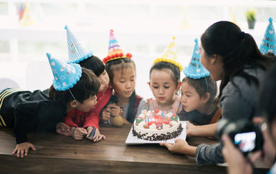 Cute happy friends enjoying birthday party at home