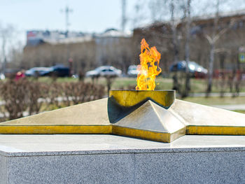 Close-up of yellow umbrella on retaining wall against buildings in city