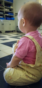 Cute baby girl sitting at home