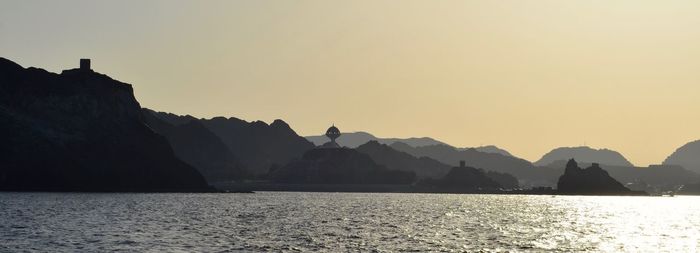 Scenic view of sea and mountains against clear sky