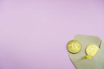 Close-up of coins on pink background