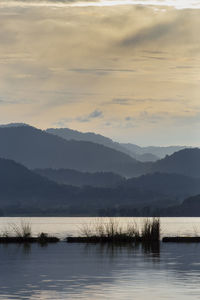 Scenic view of lake and mountains against sky during sunset