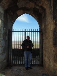 Full length portrait of man standing in historic building